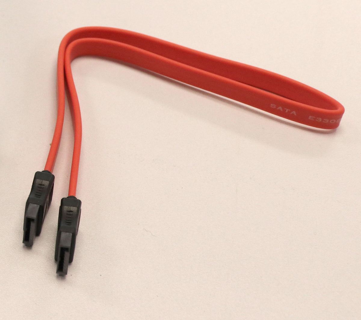 Rotes SATA-Kabel mit schwarzen Anschlüssen auf weißem Hintergrund